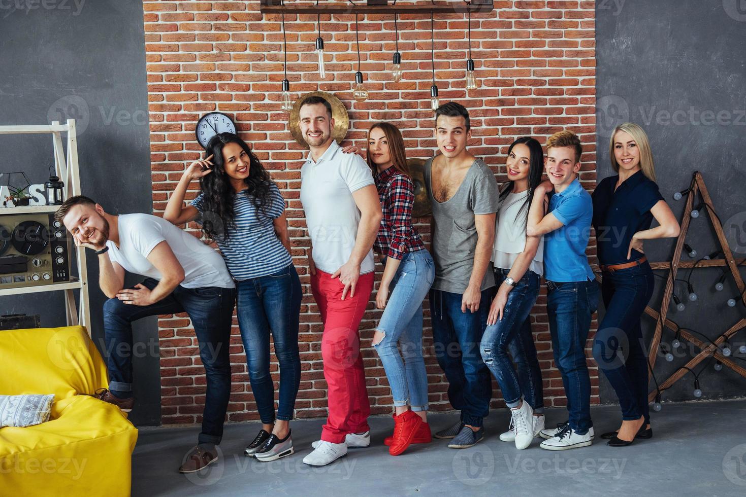 portrait de groupe de garçons et de filles multiethniques avec des vêtements colorés à la mode tenant un ami posant sur un mur de briques, des gens de style urbain s'amusant, des concepts sur le mode de vie de la jeunesse photo