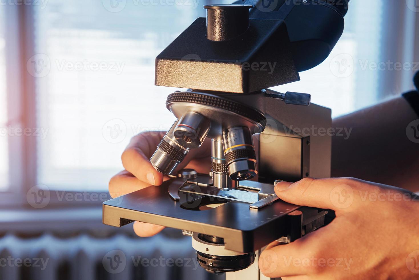 gros plan des mains scientifiques avec microscope, examinant des échantillons. photo