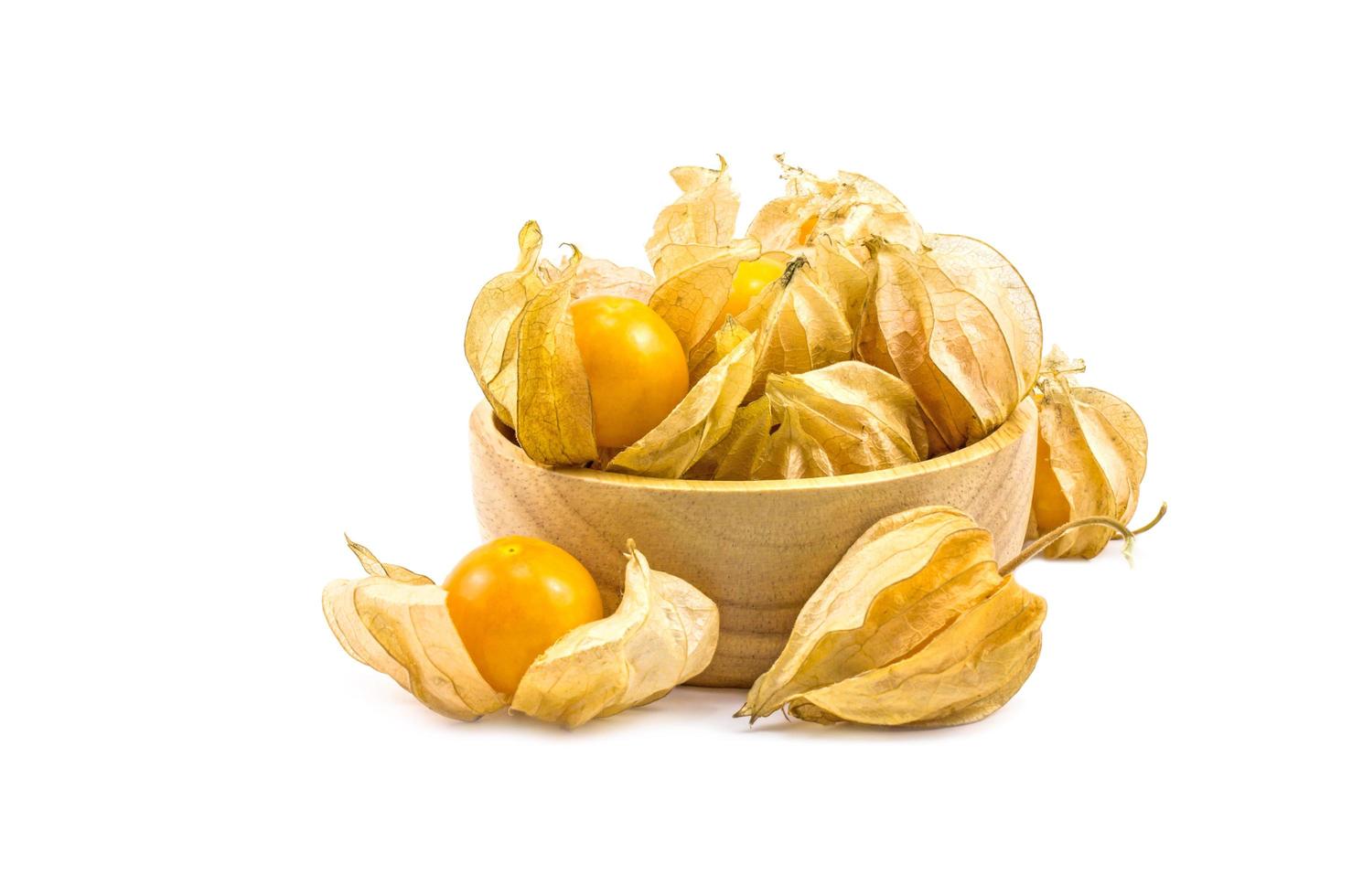 groseille du cap mis dans un bol en bois physalis isolé sur fond blanc. photo