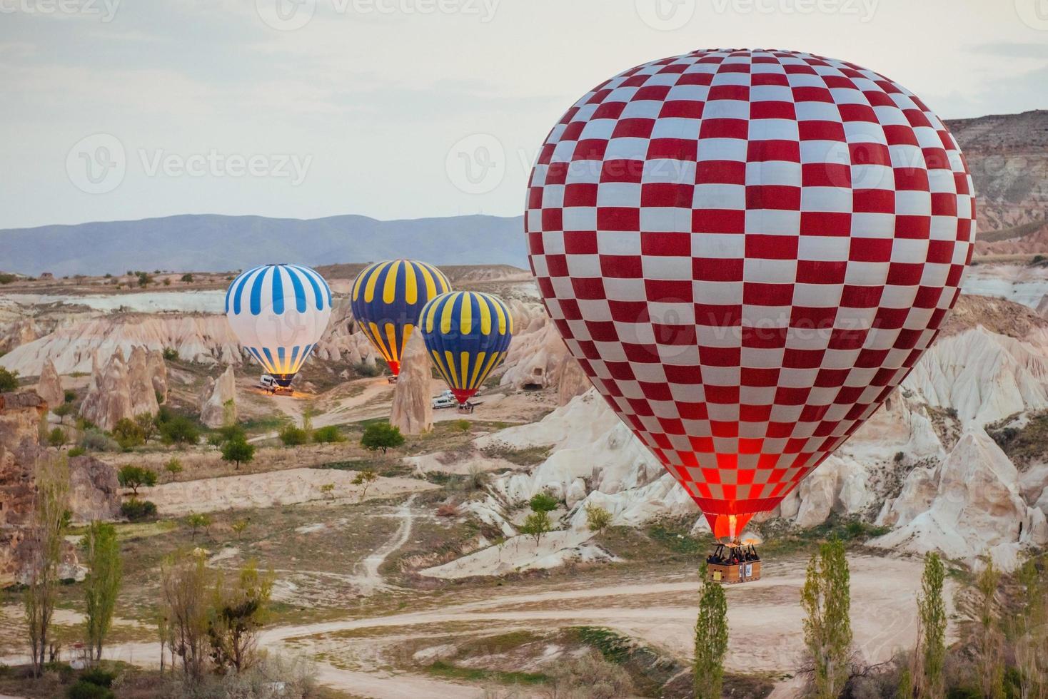 ballon à air chaud survolant le paysage rocheux en turquie. cappadoce photo