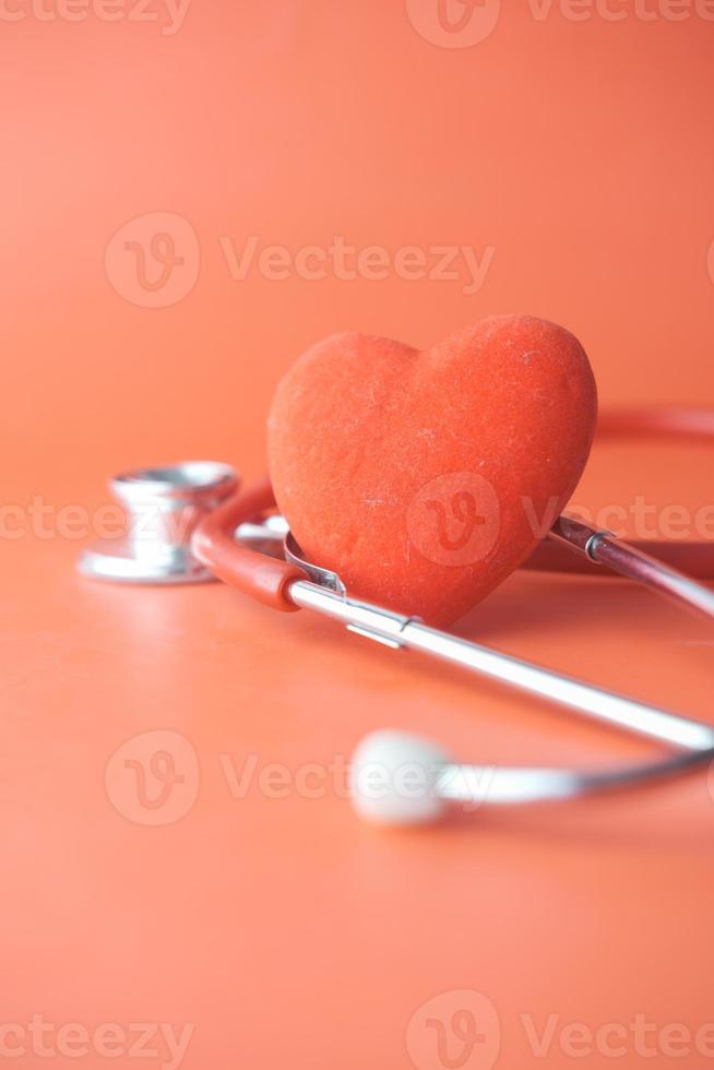 symbole en forme de coeur et stéthoscope sur fond rouge photo