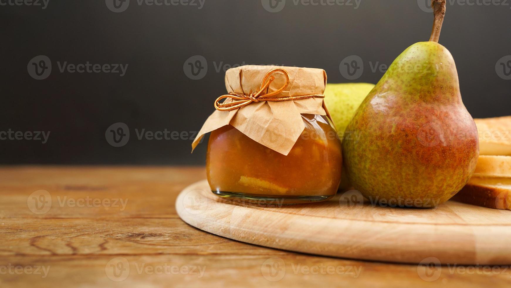 délicieuse confiture de poire et fruits frais sur une planche à découper en bois. confiture maison photo