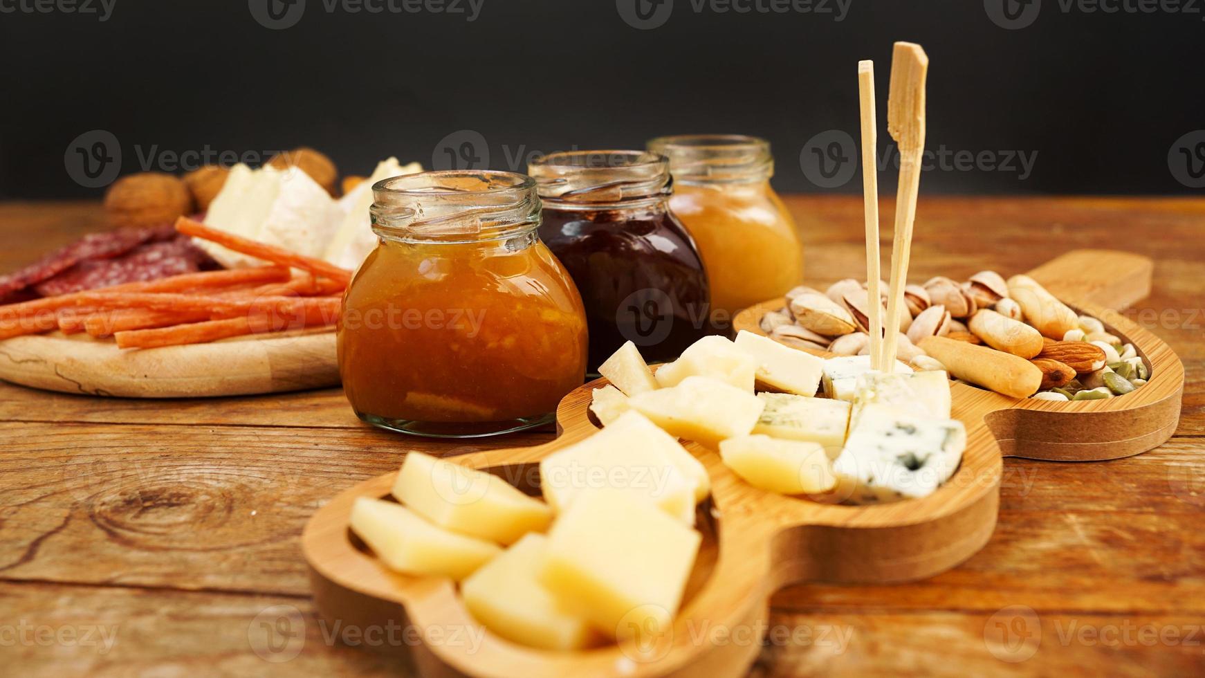 assiette de viande et de fromage pour les apéritifs. pots de confiture et de miel. photo