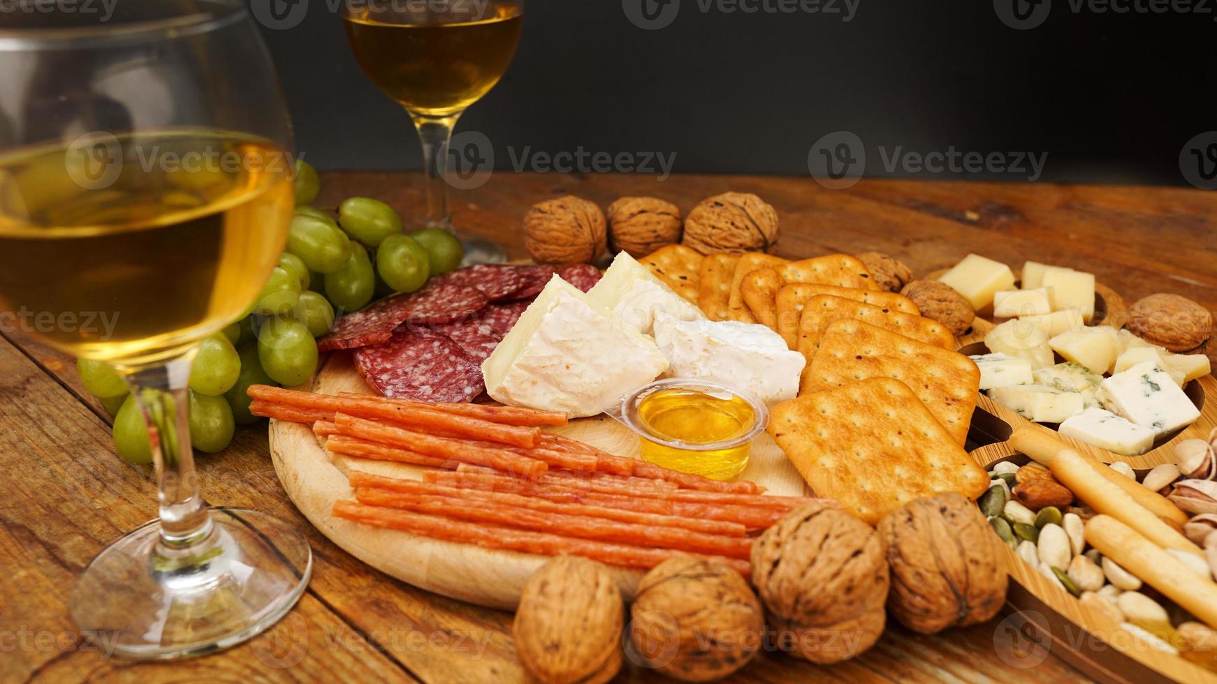 collations pour le vin. assiette de fromage et de viande. saucisses, fromage, noix, raisins, craquelins photo