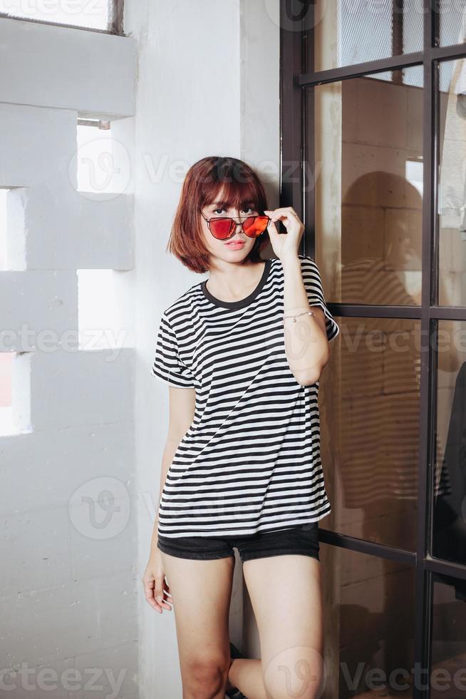 femme asiatique à la mode avec des tees rayés et des lunettes de soleil photo