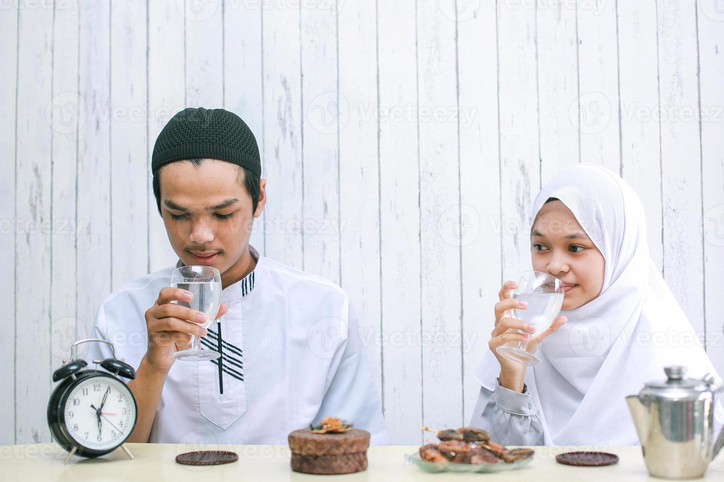 jeune couple musulman buvant ensemble à l'heure de l'iftar. ramadan traditionnel, repas iftar. concept de mois de jeûne du ramadan kareem photo