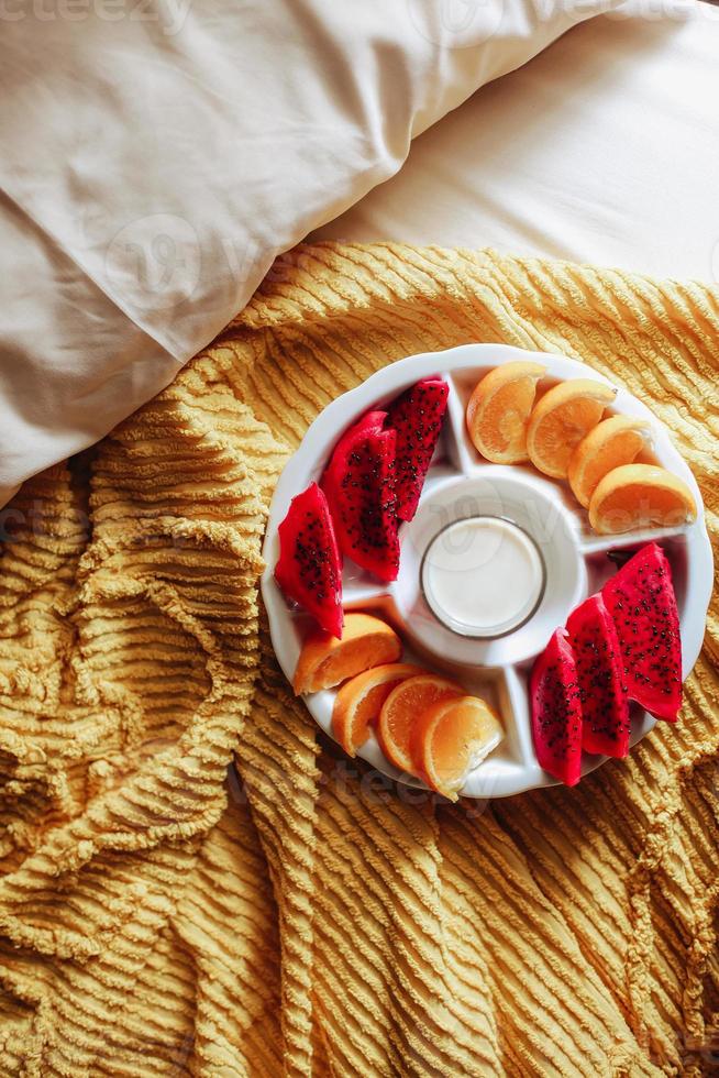 divers fruits et lait pour le petit déjeuner sur le lit photo