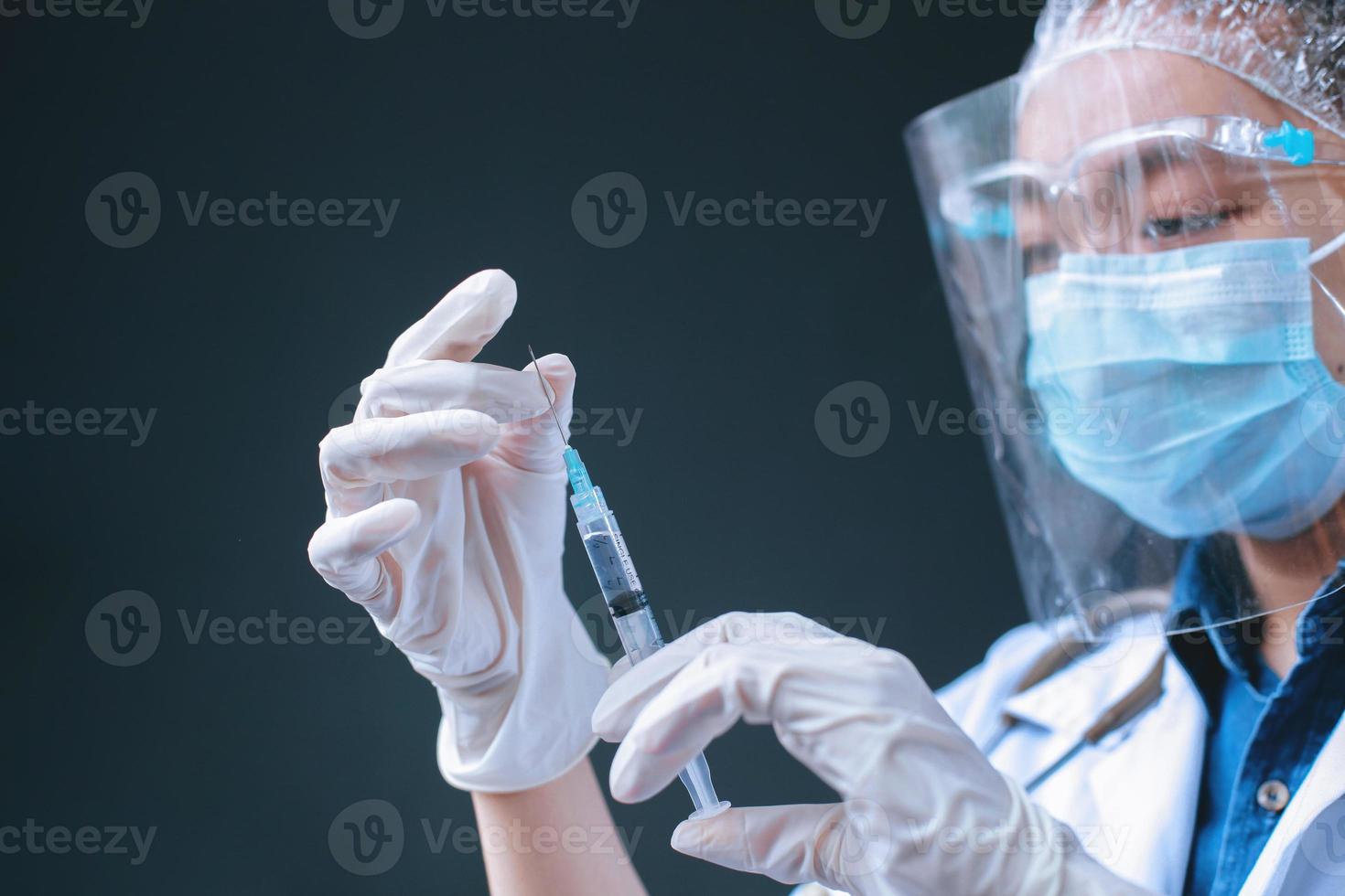 femme médecin ou scientifique asiatique en masque avec seringue, préparez-vous pour l'injection. concept de médecine, de vaccination, d'immunisation et de soins de santé photo