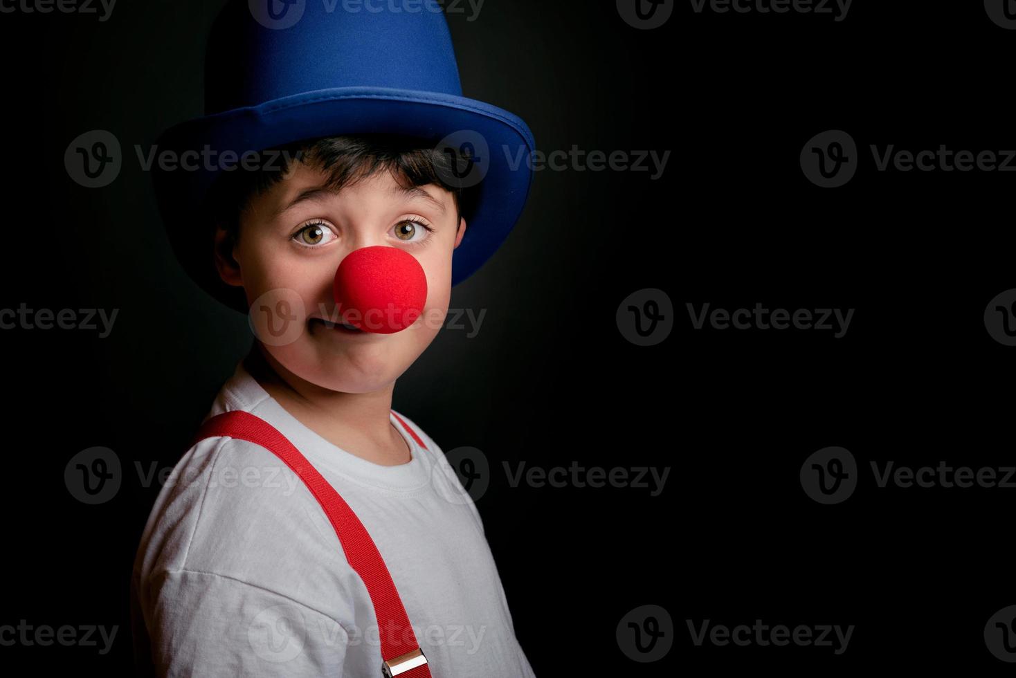 enfant drôle avec le nez et le chapeau de clown photo