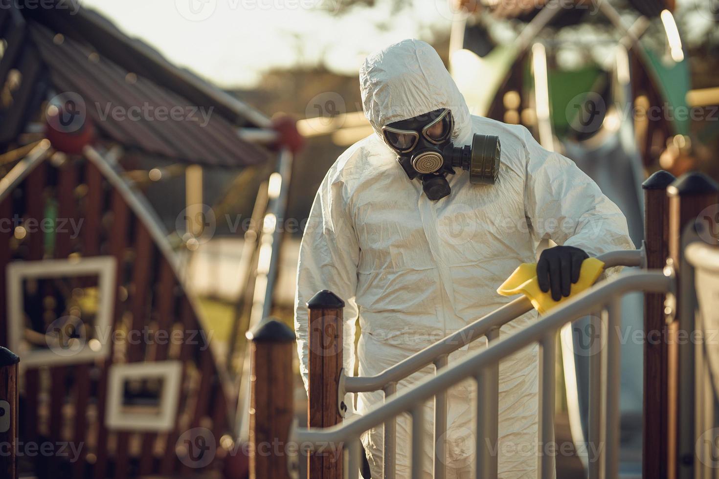 nettoyage et désinfection sur le terrain de jeu dans le complexe de la ville au milieu de l'épidémie de coronavirus équipes pour les efforts de désinfection prévention et contrôle des infections de la combinaison et du masque de protection épidémique photo