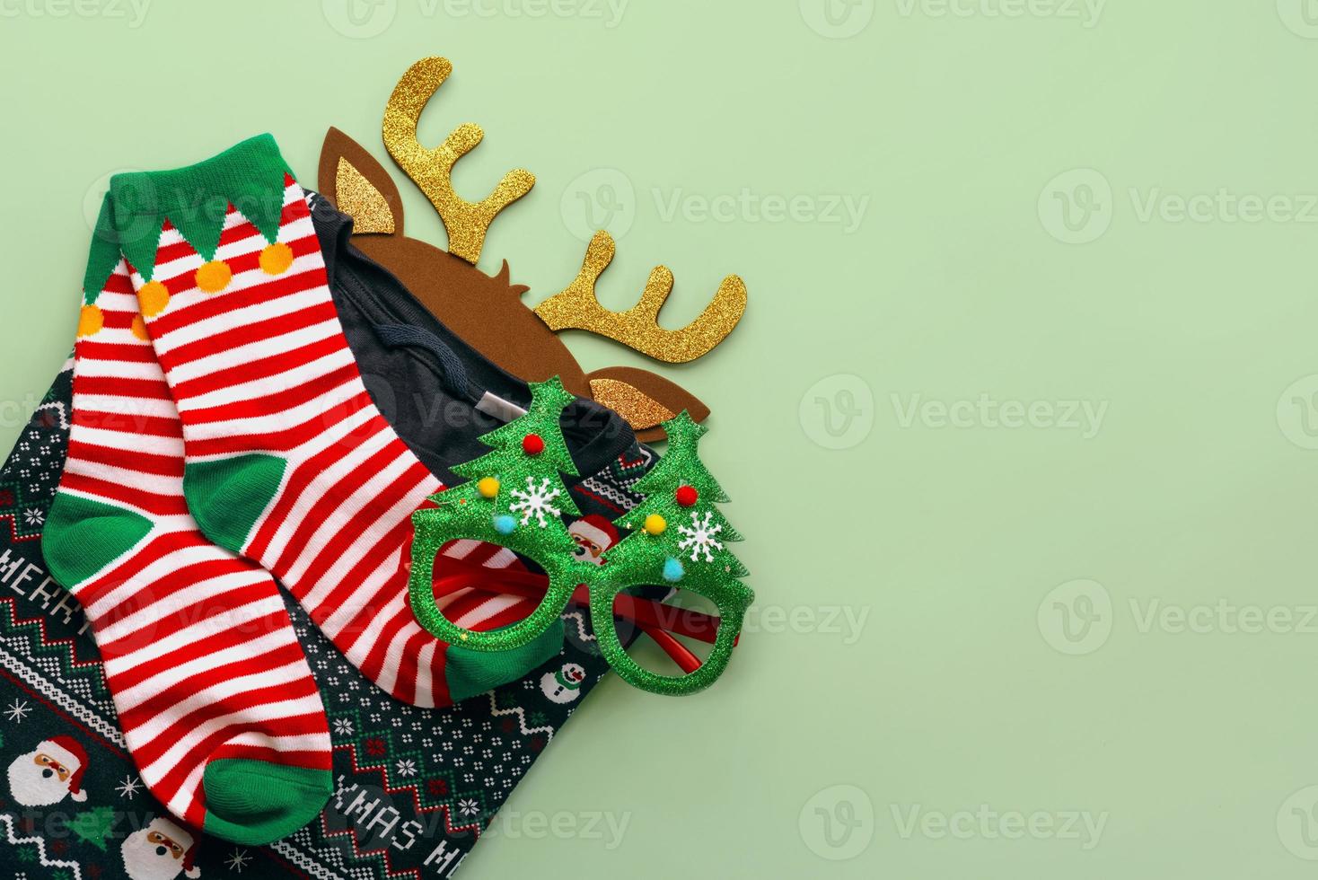 joyeux Noël. vue de dessus du chandail de noël avec des chaussettes de noël, des bois de cerf de jouet de noël lumineux et des lunettes amusantes. fond de concept de noël photo