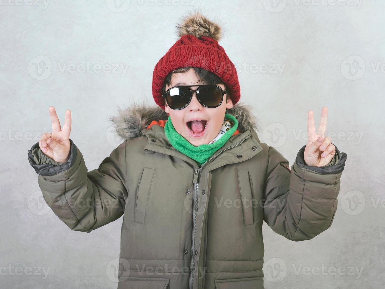 enfant heureux avec des lunettes de soleil et un chapeau d'hiver photo