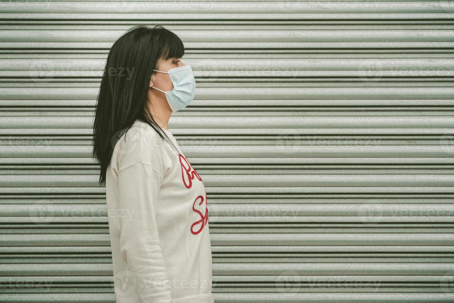 femme portant un masque médical pour le coronavirus marchant dans la rue photo