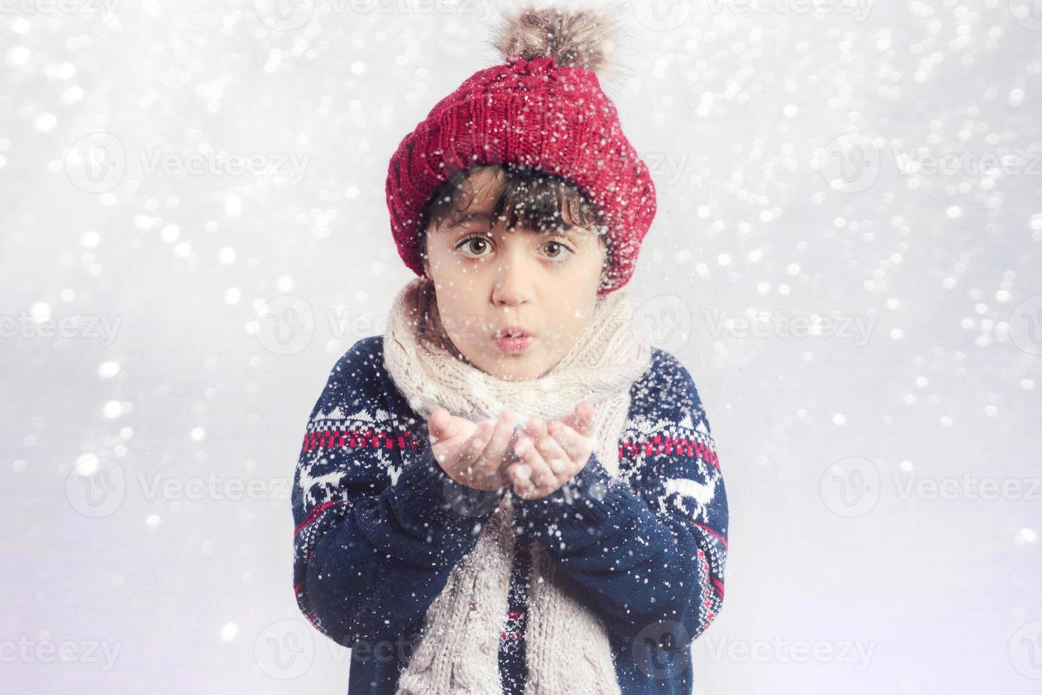 petit enfant souffle la neige des mains à noël photo