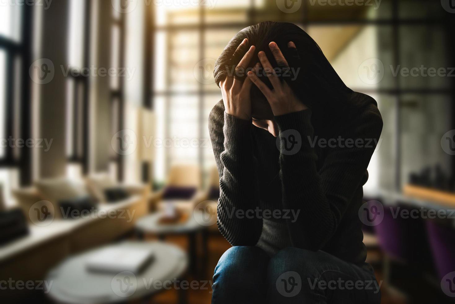 femme assise dépression debout près de la fenêtre photo