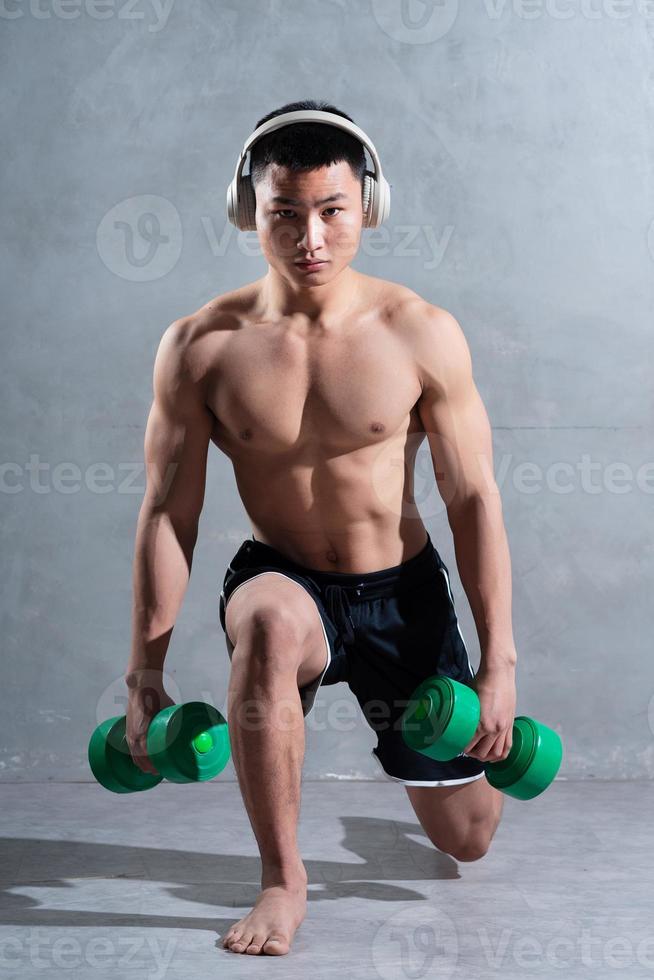 homme asiatique musclé posant sur fond gris photo