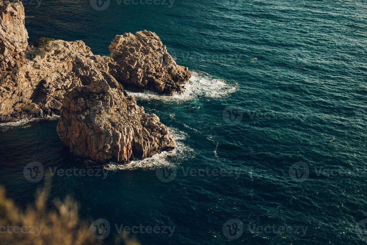 quelques rochers et une mer d'un bleu profond photo