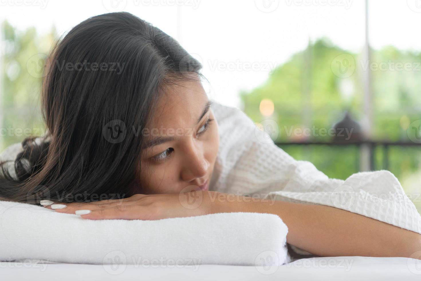 portrait d'une belle jeune femme asiatique profite d'un massage dans une station thermale de luxe photo