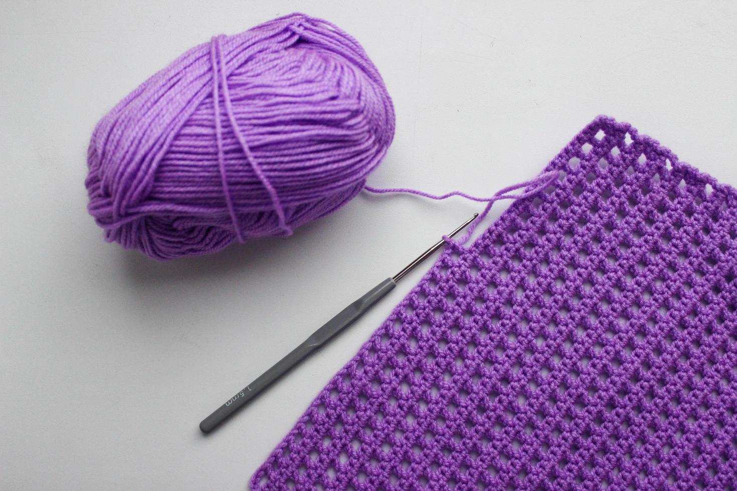 pelote de laine, crochet et un morceau de lin tricoté photo