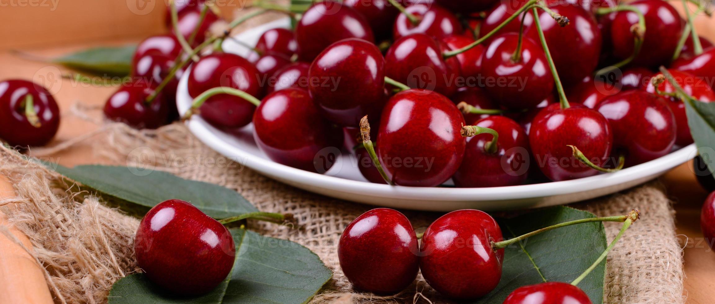 gros plan sur un tas de cerises mûres avec des tiges et des feuilles photo