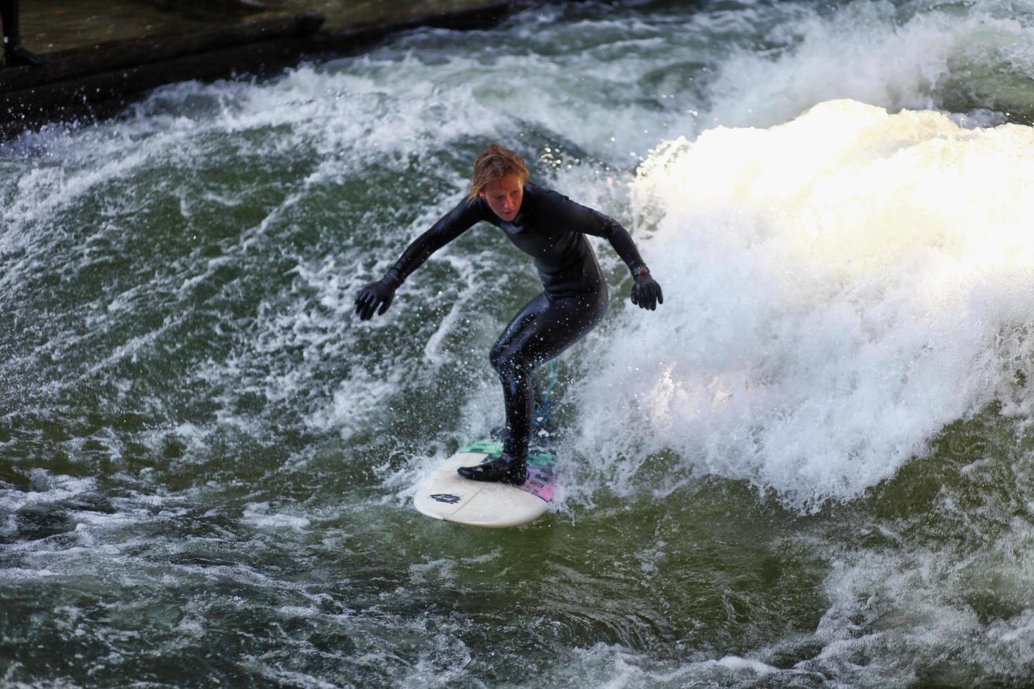 munich, allemagne - 23 octobre 2011 - surfeur non identifié dans la rivière eisbach dans le jardin anglais de munich, allemagne le 23 octobre 2011. les premiers surfeurs ont découvert l'eisbach dans les années 1970. photo