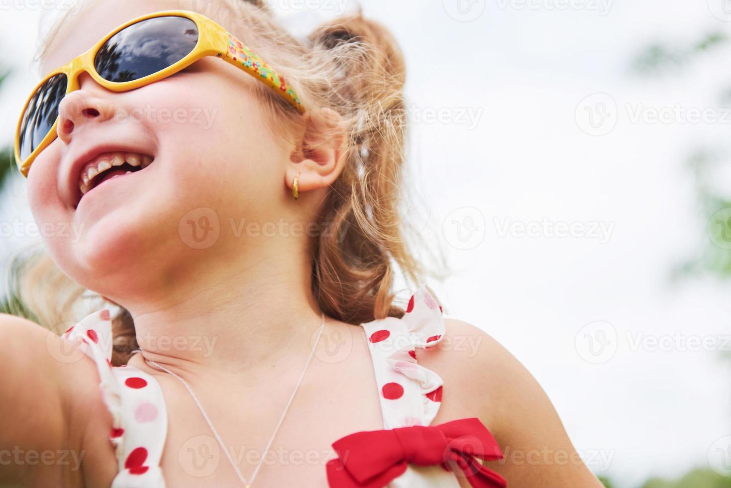 petite fille heureuse dans des lunettes de soleil d'été photo