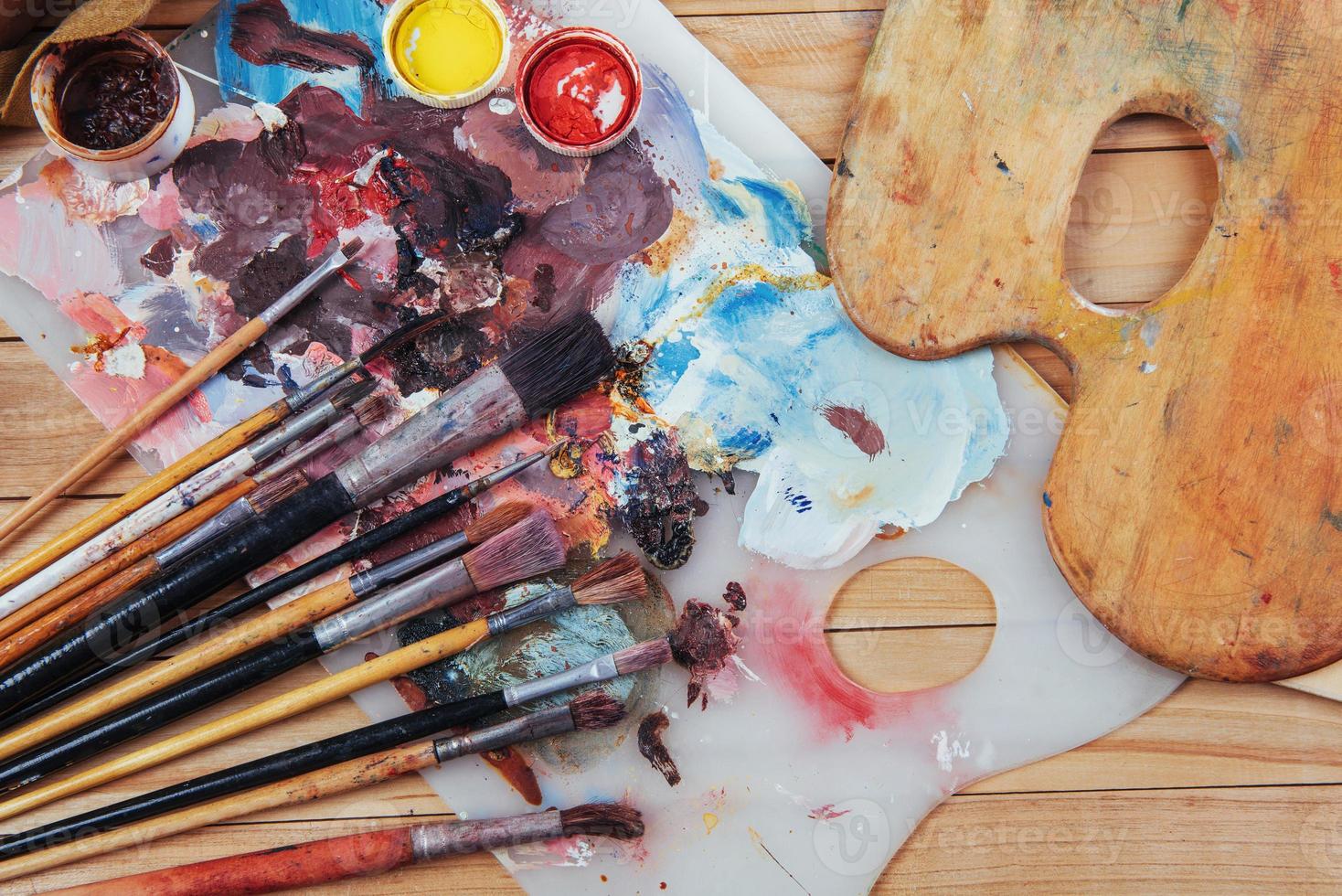 pinceau d'art et encres colorées dans des boîtes sur fond sombre. photo