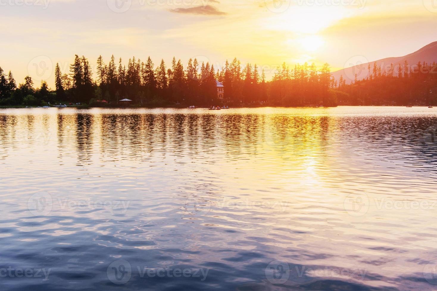 coucher de soleil sur le lac. lac de montagne majestueux dans le parc national des hautes tatras. strbske pleso, slovaquie photo