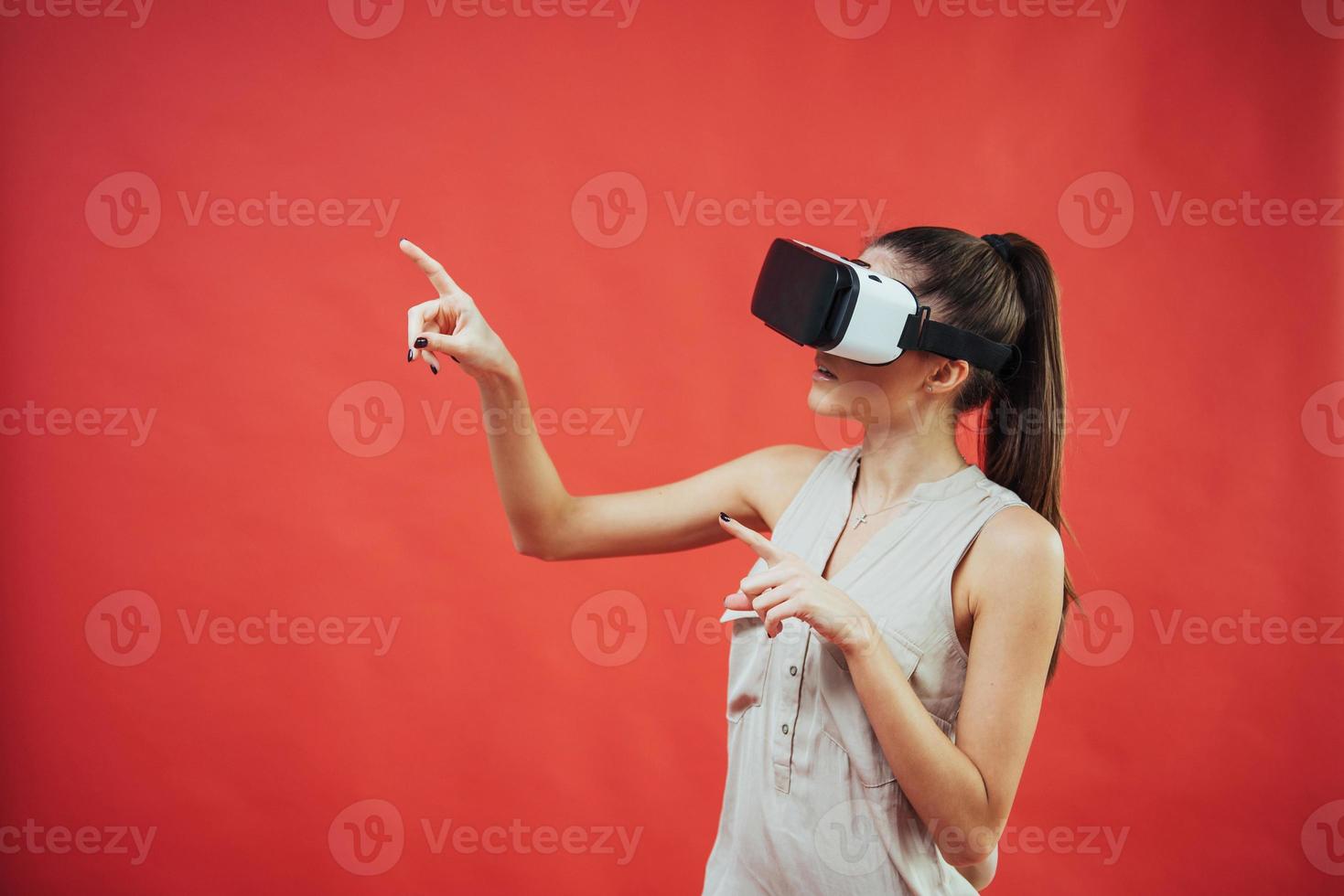 portrait d'une belle jeune fille souriante et heureuse, acquérir de l'expérience en utilisant des lunettes de réalité virtuelle pour casque vr, isolées photo