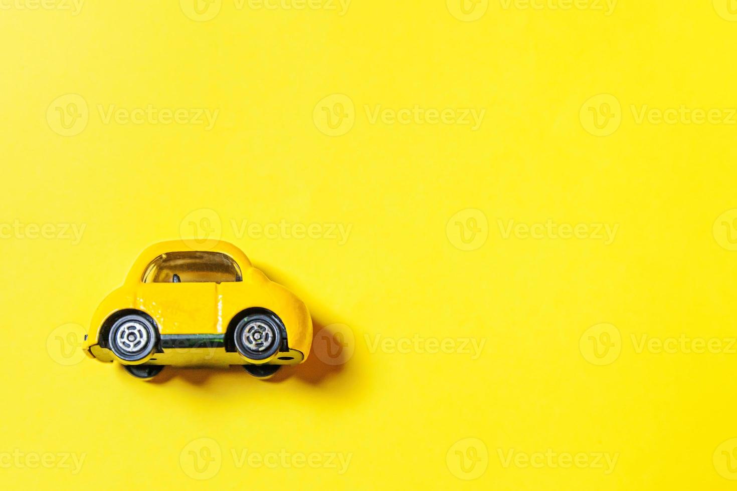concevez simplement une voiture de jouet rétro vintage jaune isolée sur fond jaune. symbole de l'automobile et du transport. espace de copie du concept de livraison du trafic urbain photo