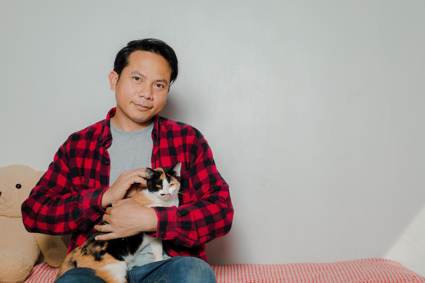 l'homme a utilisé sa main pour caresser la tête du chat comme lui. photo