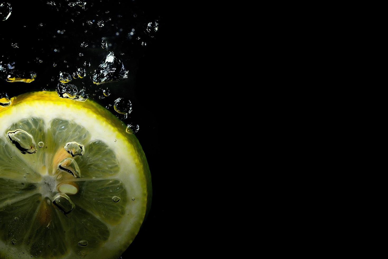 le citron tombe dans des bulles d'eau photo