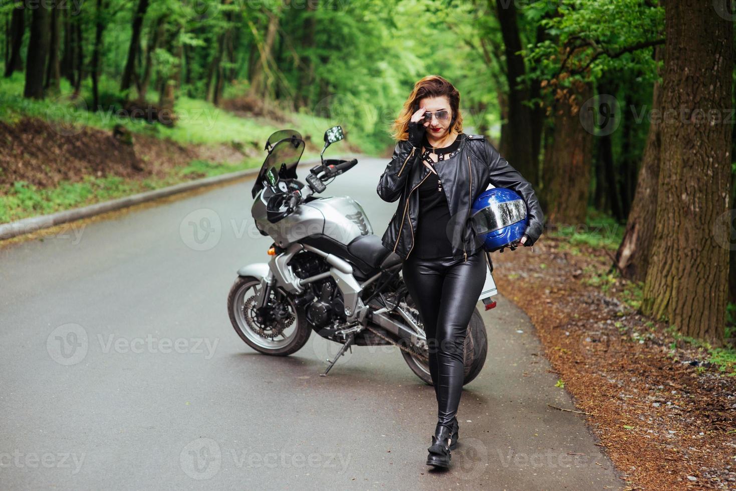 une jolie fille sexy sur une moto de sport posant à l'extérieur photo