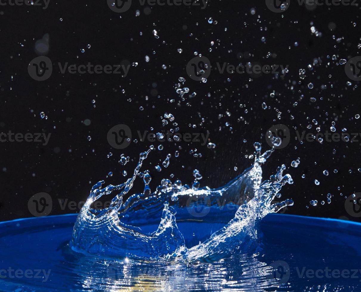 éclaboussure de couronne d'eau sur la surface bleue. photo