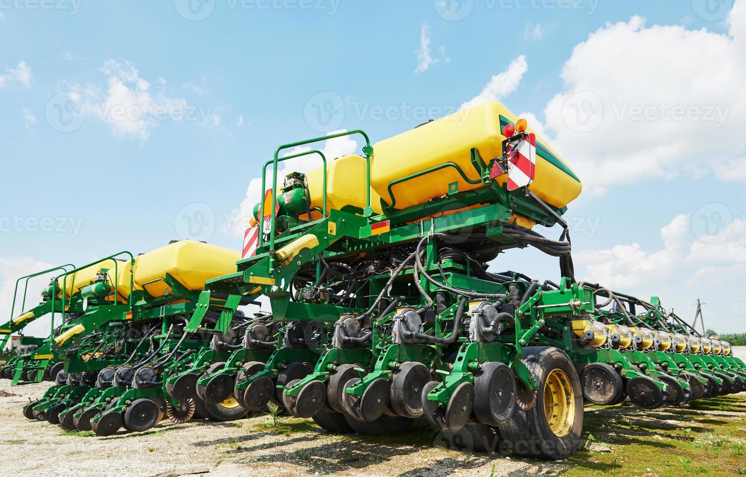 gros plan du semoir attaché au tracteur dans le champ. machines agricoles pour travaux de printemps semis photo