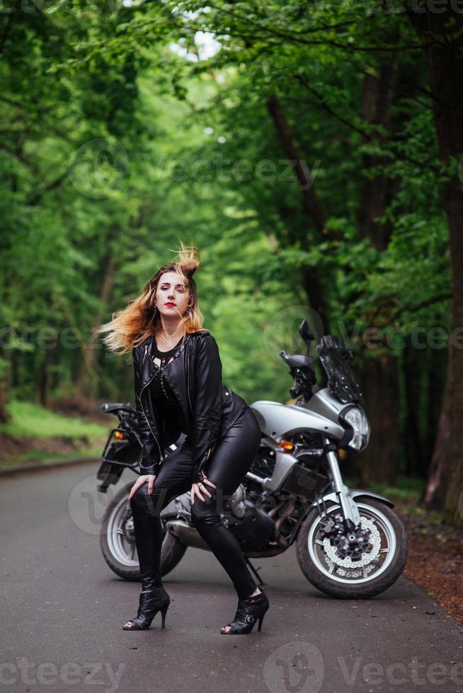 une jolie fille sexy sur une moto de sport posant à l'extérieur photo