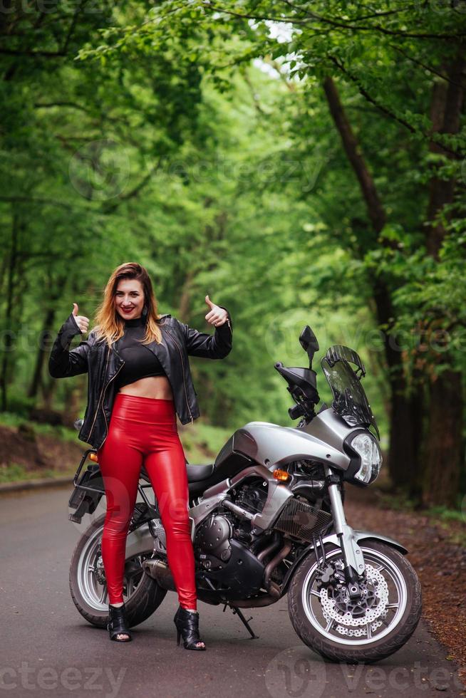 une jolie fille sexy sur une moto de sport posant à l'extérieur photo