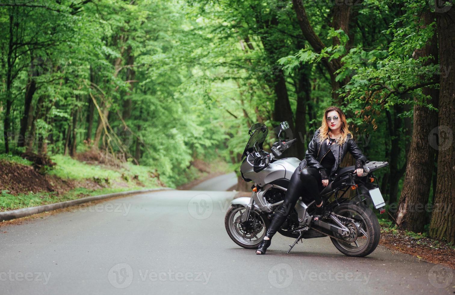 une jolie fille sexy sur une moto de sport posant à l'extérieur photo