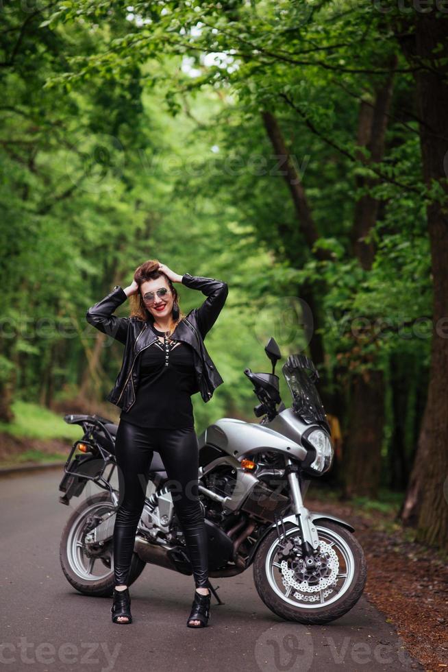 une jolie fille sexy sur une moto de sport posant à l'extérieur photo