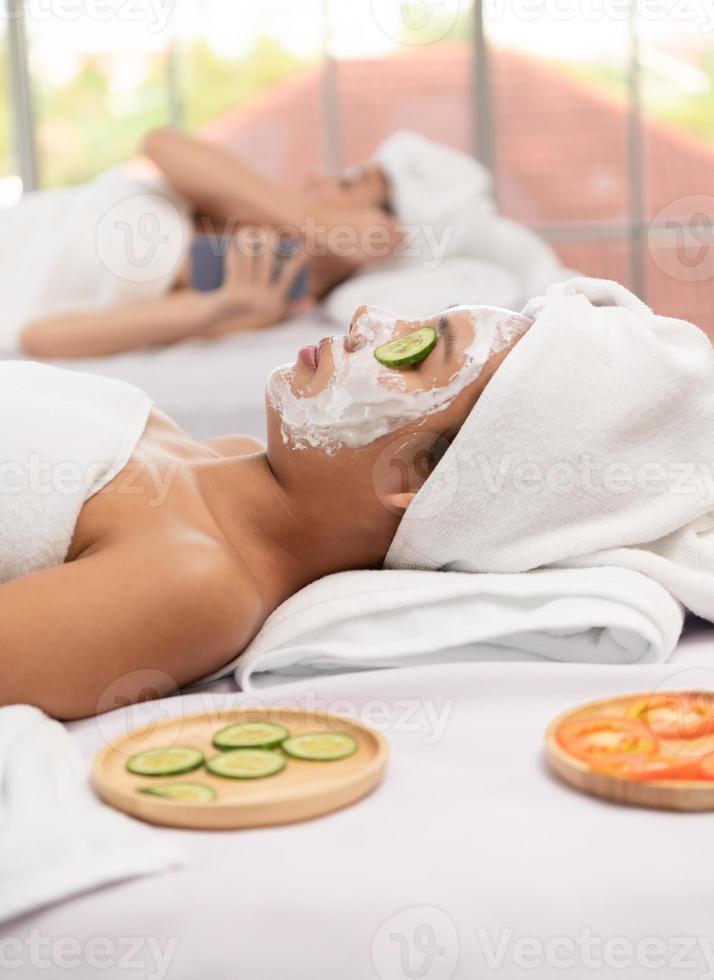 portrait d'une belle jeune femme asiatique profite d'un massage dans une station thermale de luxe photo