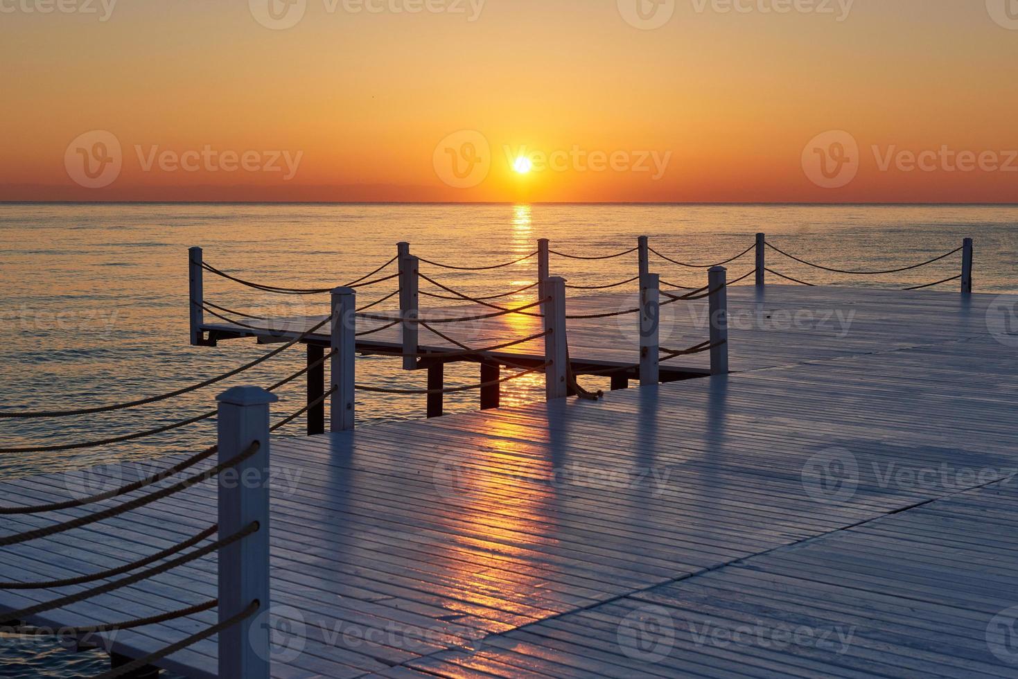 jetée en bois sur un coucher de soleil orange fantaisie. photo