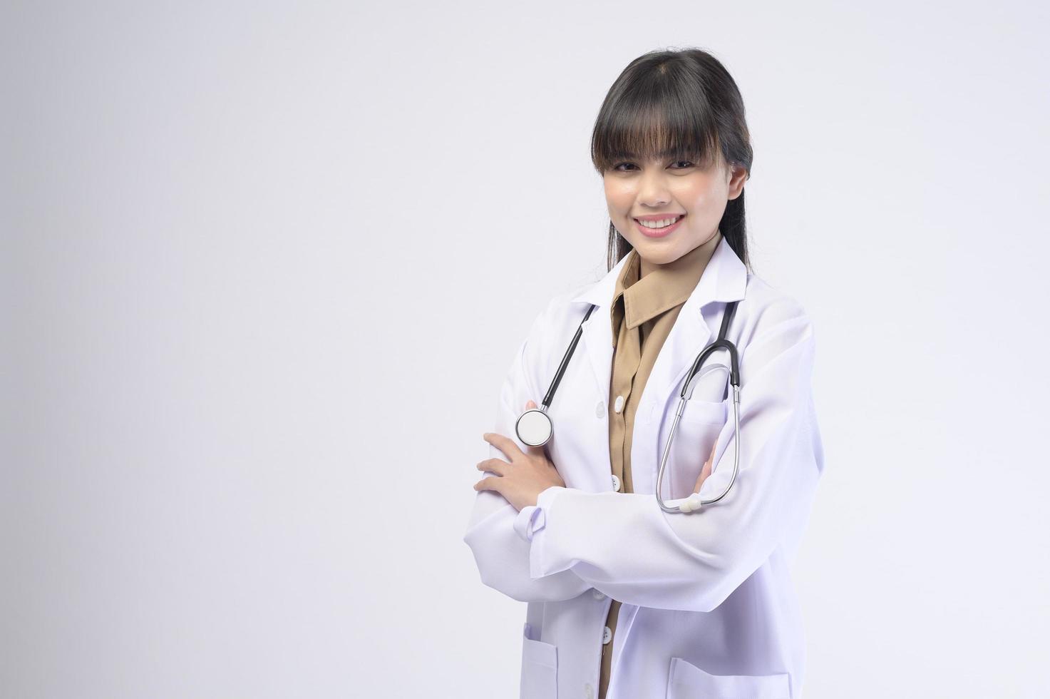 Jeune femme médecin avec stéthoscope sur fond blanc photo