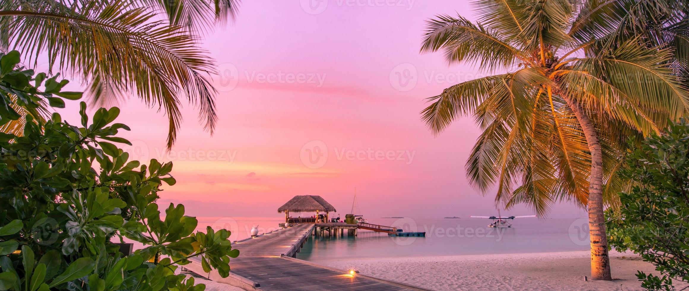 scène de plage panoramique tranquille au coucher du soleil. vue colorée sur le ciel et les nuages avec une mer calme et une ambiance tropicale relaxante photo