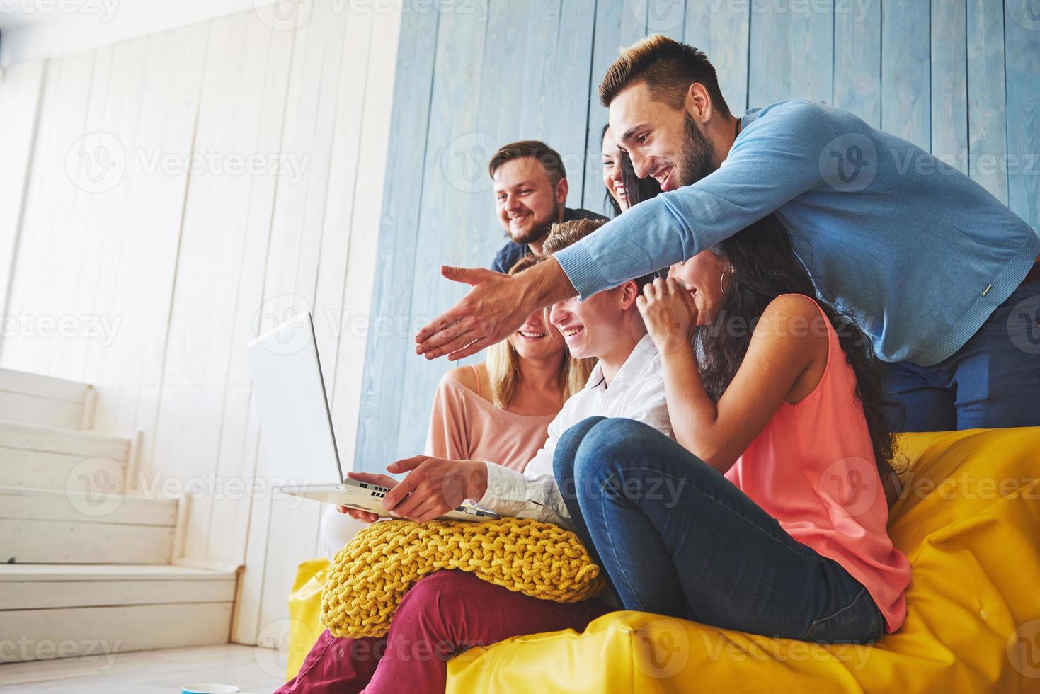 groupe de jeunes amis créatifs suspendus au concept de médias sociaux. les gens discutent ensemble d'un projet créatif pendant le processus de travail, jouent à des jeux ou regardent un film vidéo photo