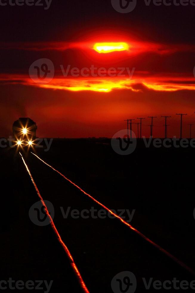 vue panoramique d'un train qui approche près du coucher du soleil photo