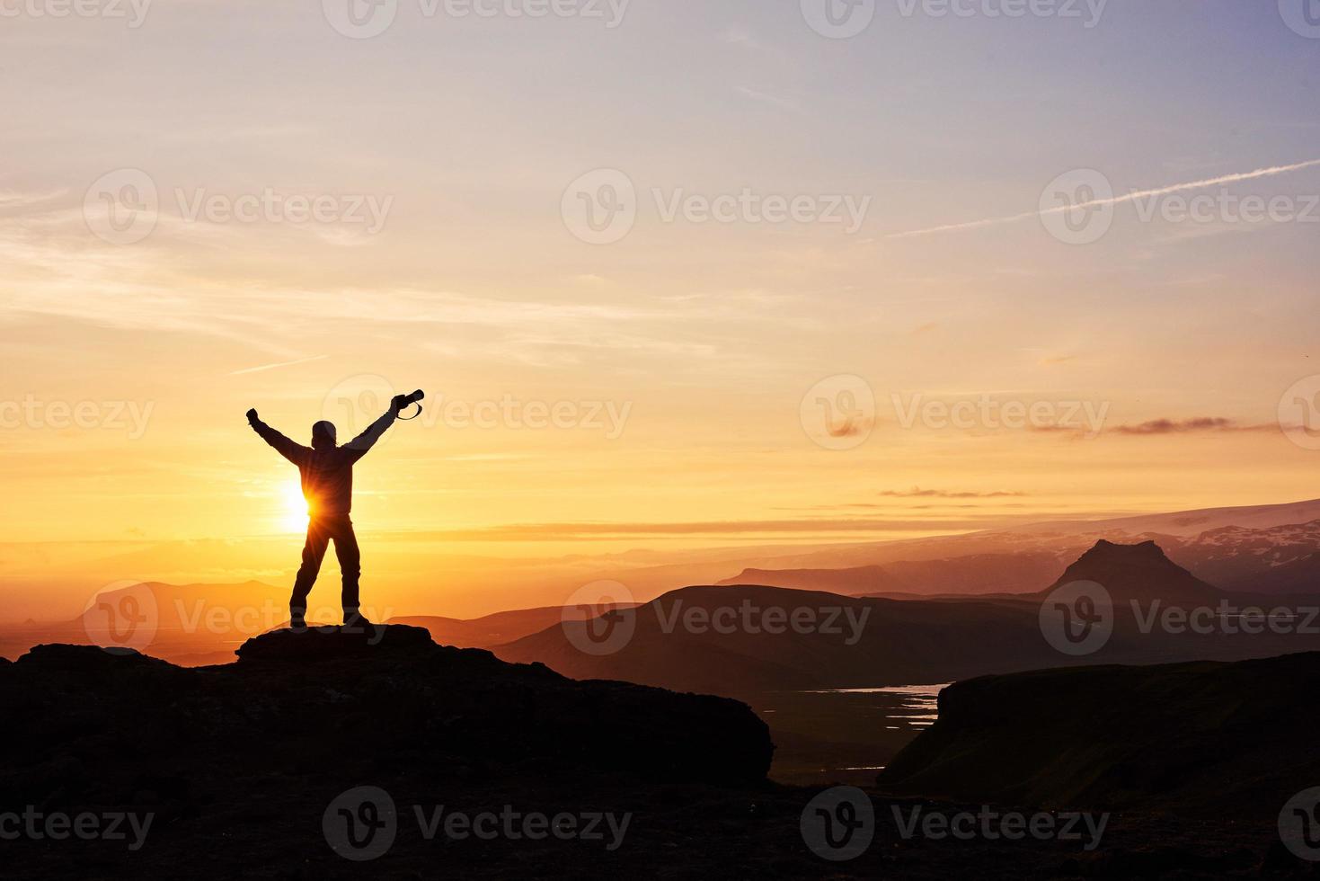 silhouette d'un homme au sommet d'une montagne. silhouette de personne sur le rocher. concept de sport et de vie active photo