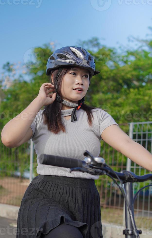 jeune femme asiatique appréciant le cyclisme à l'arrêt le matin d'été photo