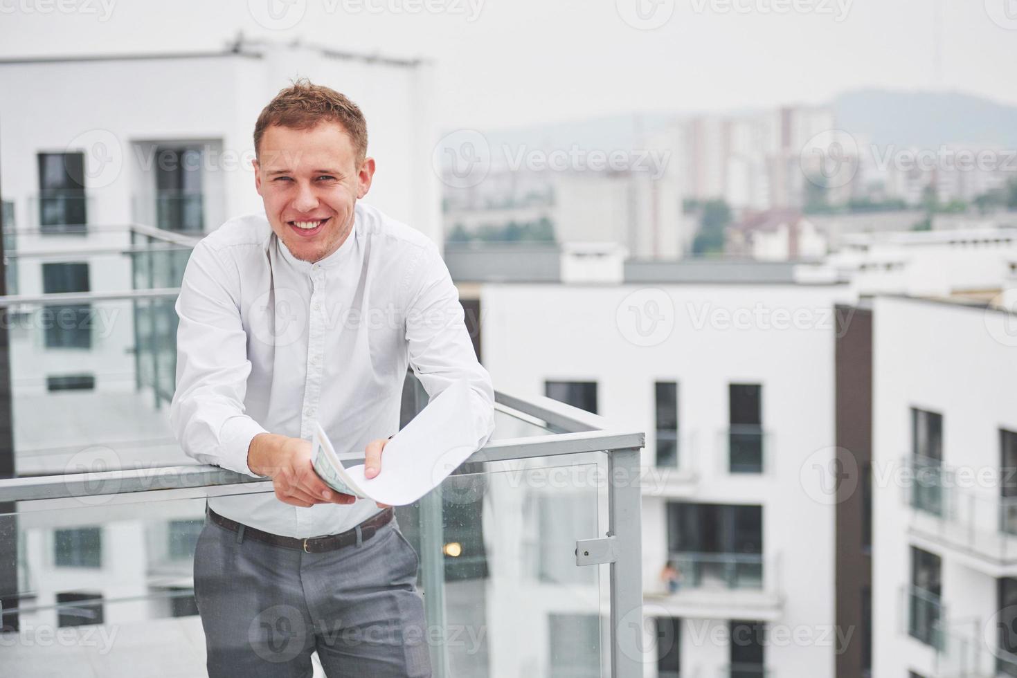 souriant jeune architecte ou constructeur d'ingénierie en casque avec tablette sur un groupe de constructeurs sur le chantier de construction, architecte regardant une construction, entreprise, bâtiment, industrie, concept de personnes photo