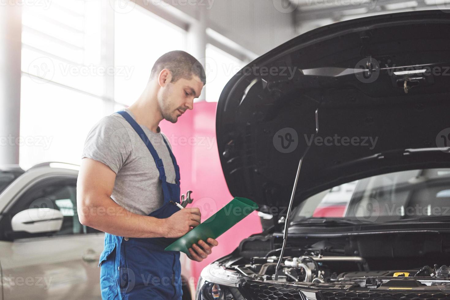 portrait d'un mécanicien au travail dans son garage - service de voiture, réparation, entretien et concept de personnes photo