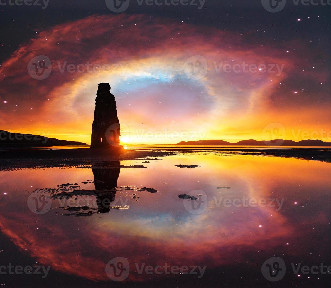 ciel étoilé dans un rocher spectaculaire dans la mer sur la côte nord de l'islande. les légendes disent que c'est un troll pétrifié. photo